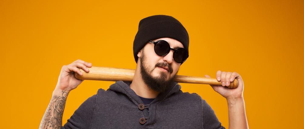 Man with sunglasses, beanie and bat.