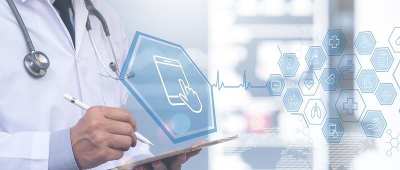 Healthcare professional with stethoscope using digital tablet with medical icons and smartphone interface overlay.