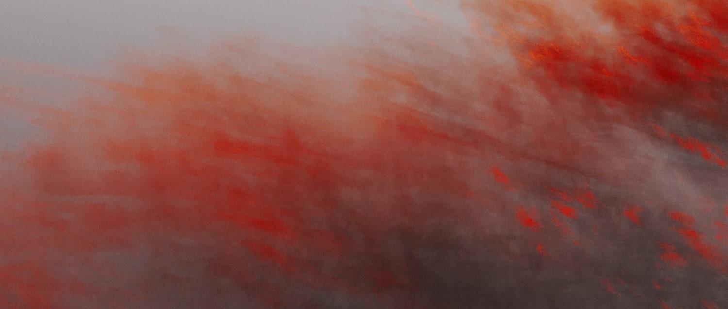 Abstract image with swirling red and grey smoke-like patterns creating a dramatic, misty atmosphere.