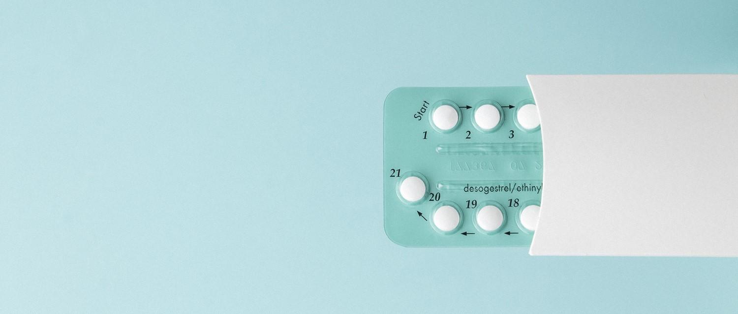 Birth control pill pack showing numbered white tablets in a teal blister pack against a light blue background.